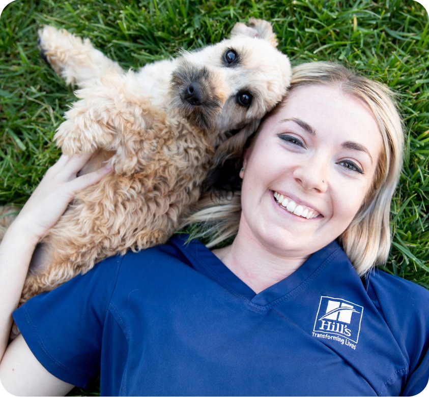 Perro con veterinaria acostados en el césped